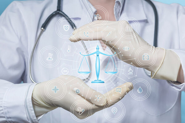 A person wearing a white lab coat and gloves holds a virtual icon of scales, surrounded by medical and legal symbols.