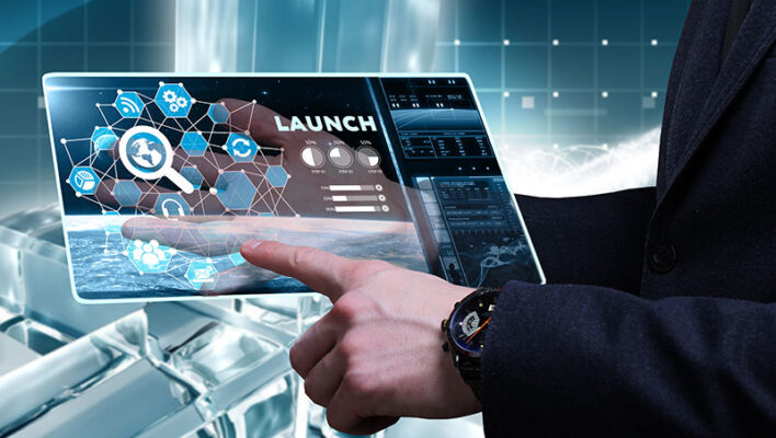 A person interacts with a transparent touchscreen displaying various icons and graph in a high-tech environment.