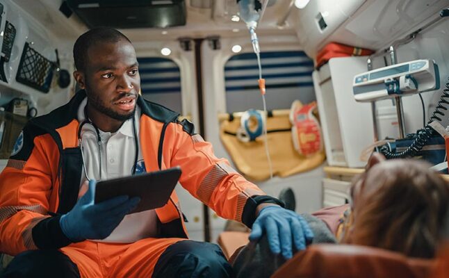 An EMT using a tablet in an ambulance to access 5G-enabled health care services.