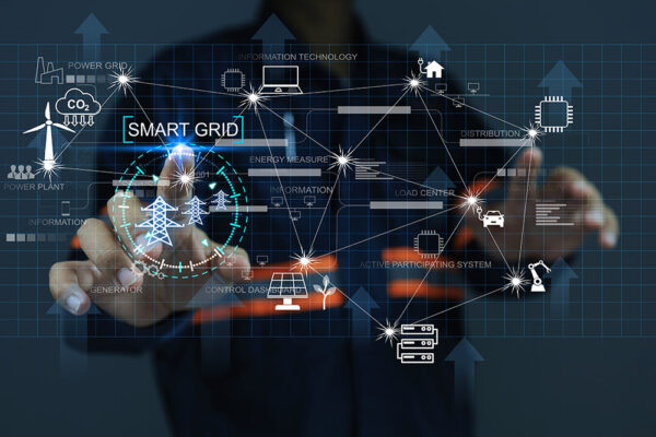 A person interacts with a holographic display showing a smart grid network for energy management.