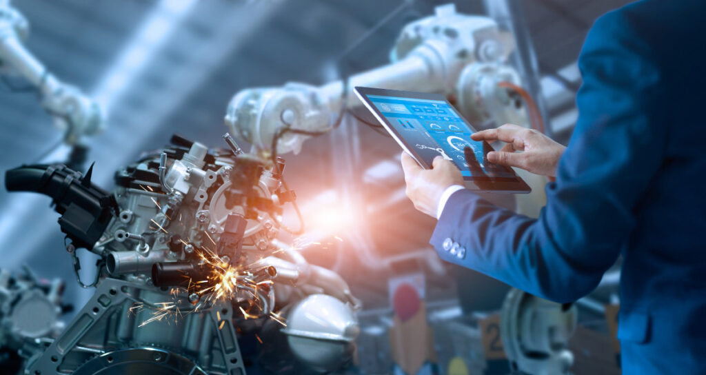 A man in a suit is using a tablet at Allied Automation factory.