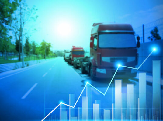 Convoy of trucks on a highway overlaid with rising graph.