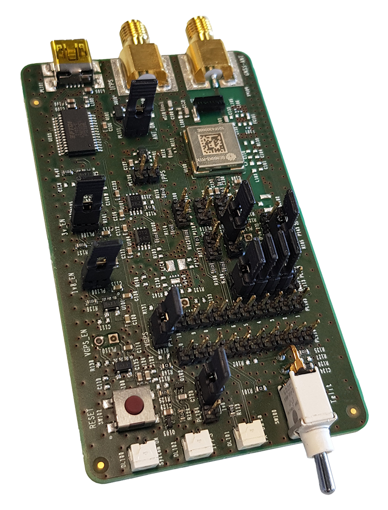 A green printed circuit board featuring various integrated circuits, connectors, and components including a white switch and gold connectors on the top edge.
