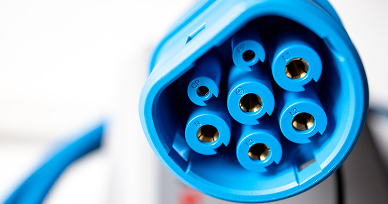 Close-up of a blue electric vehicle supply equipment charging connector.