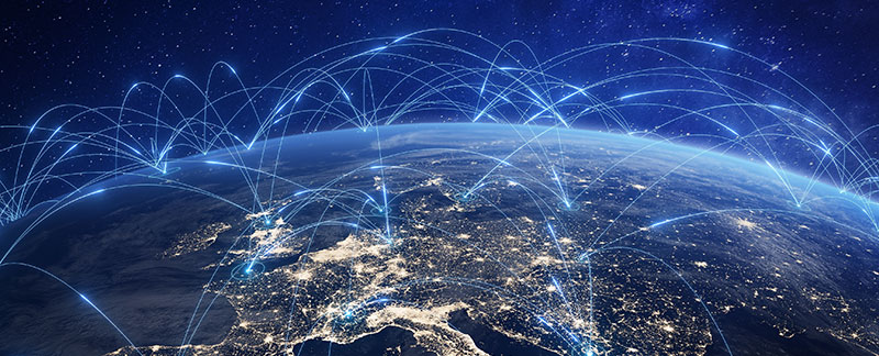 A view of Earth from space at night, showing illuminated cities and blue lines representing global communication networks.