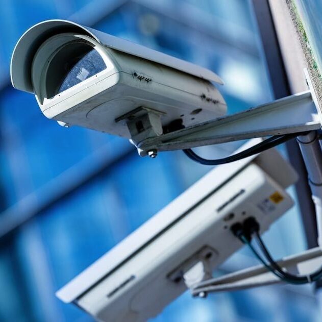 Two cctv cameras in front of a smart building.