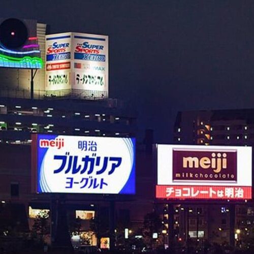 A group of smart digital billboards in a city at night.