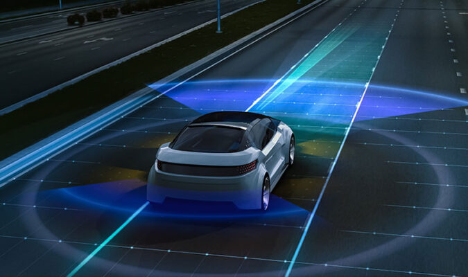 A self-driving car navigates a road at night, using visualized sensors to detect its surroundings.