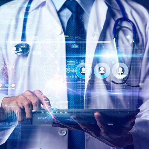 A doctor holds a laptop, which is receiving health care data.