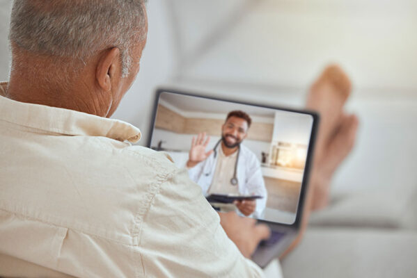 A person joins a medtech-driven video call with a doctor, who is smiling and waving.