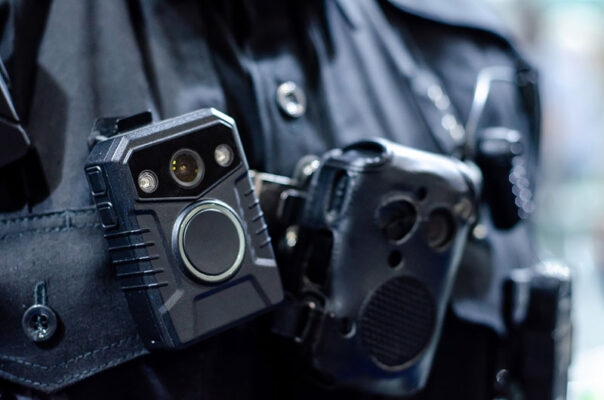 Close-up of a police officer's uniform showcasing body-worn cameras securely attached to the chest area.