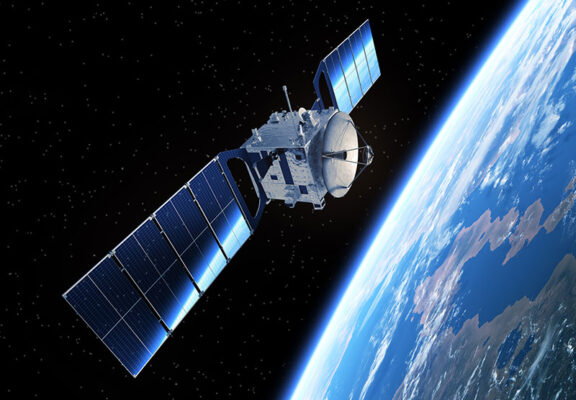 A satellite with solar panels orbits Earth, seamlessly integrating dual-mode cellular and NTN technology for enhanced communication capabilities.