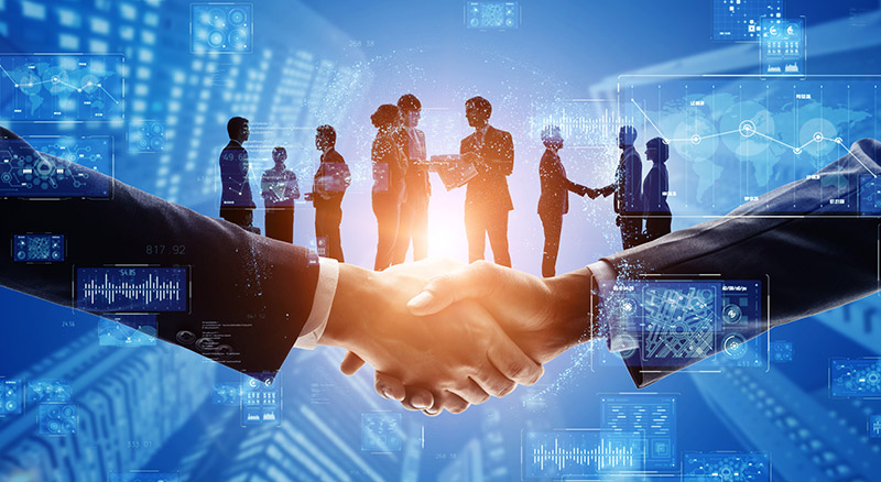 Two people shaking hands with a group of partners standing in the background, overlaid with digital data.
