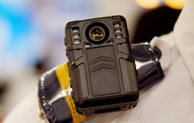 Close-up of a black body-worn camera mounted on a shoulder.
