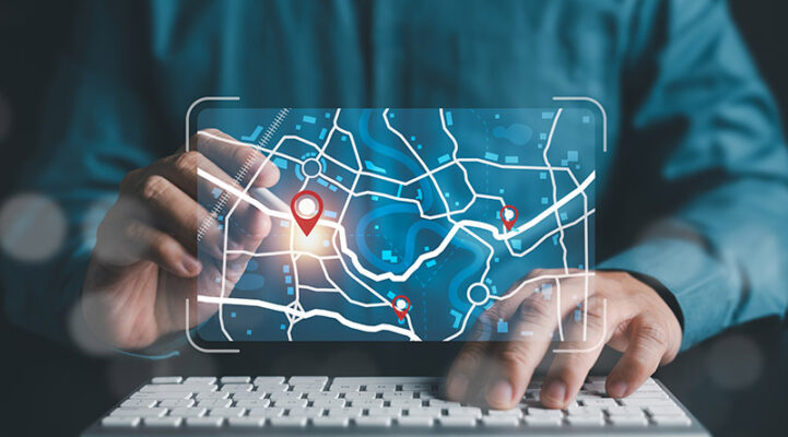 A person using a computer with a digital map interface utilizes dead reckoning to enhance accuracy, as location markers are displayed on the screen.