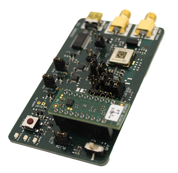 A green circuit board with various electronic components, connectors, and gold-plated terminals, placed on a white surface.