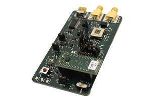 A microcontroller development board featuring various electronic components and connectors, including three yellow connectors on one end and a green circuit board attached on top.