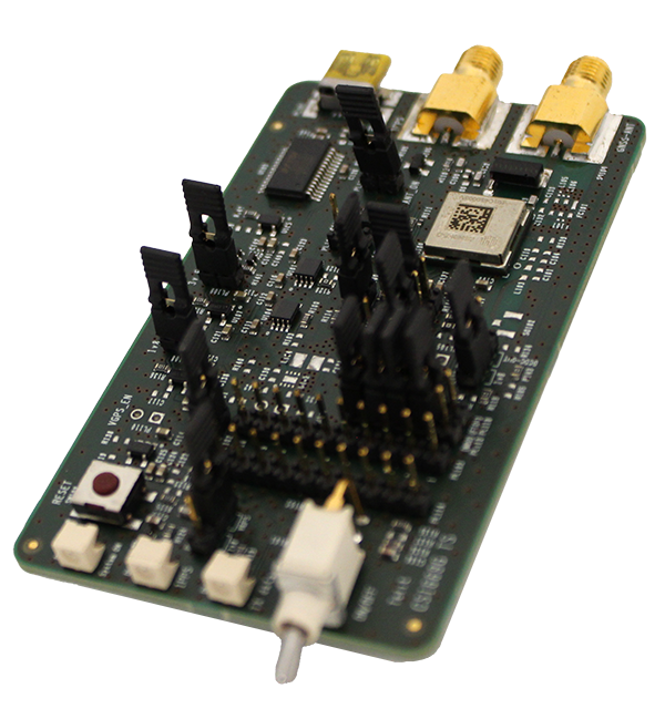 A close-up of a green circuit board with various electronic components, including connectors and pins, mounted on it.