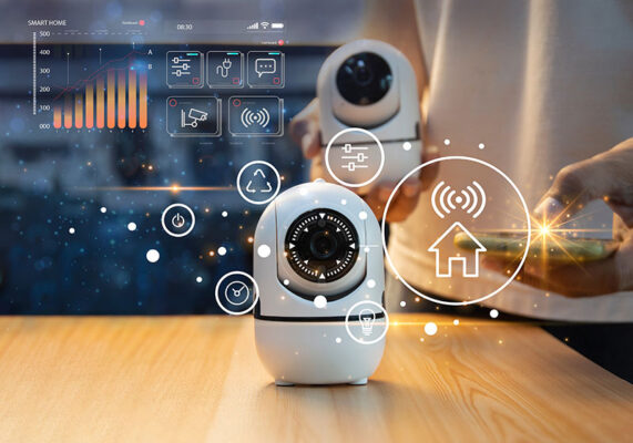 Smart home security system with surveillance cameras and alarm panels that's controlled by person holding a smart phone. Holographic icons are overlaid, showcasing connectivity features.