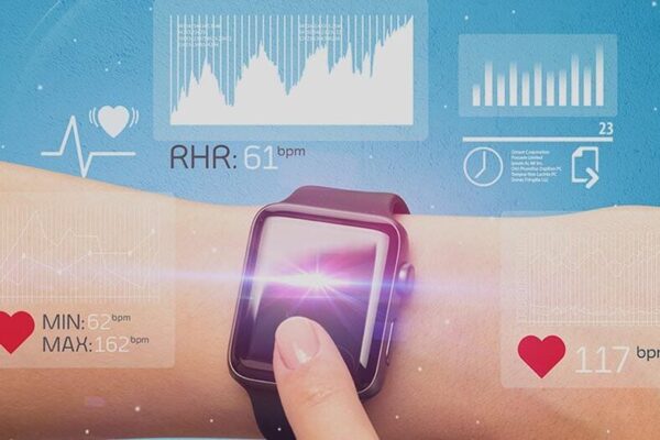 A person's wrist with a smart watch, an IoT device for health care.