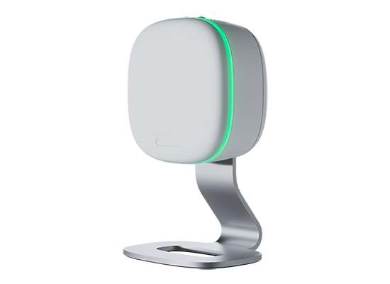 A white, square-shaped electronic device with rounded edges, mounted on a metallic stand, featuring a green LED light strip along one side.
