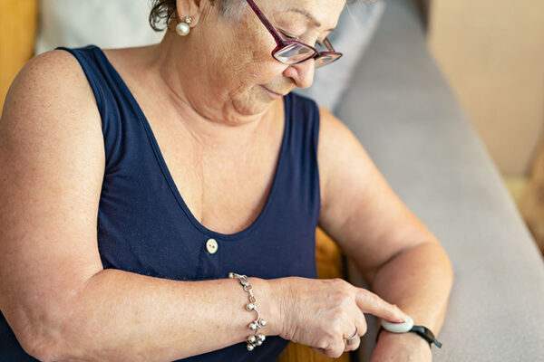 Older person checks their PERS-enabled smartwatch on their wrist.