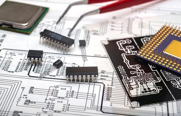 Microchips, a transistor, a circuit board and tweezers sit on top of electronic schematics,.