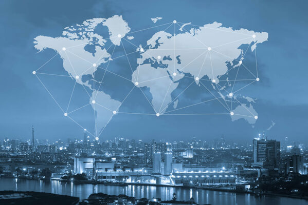 City skyline at night with a transparent world map and interconnected nodes superimposed.