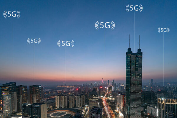 City skyline at dusk with digital 5G network symbols across various buildings.