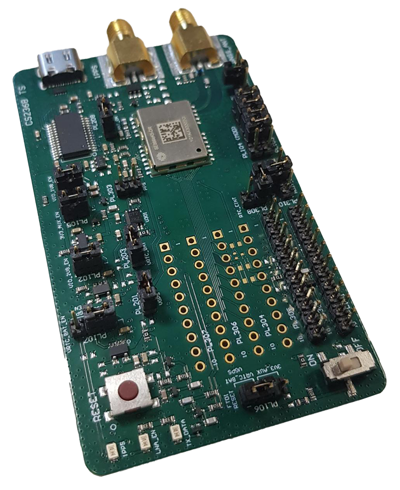 Green printed circuit board with various electronic components, connectors, two SMA antennas, a microchip, and labeled pins.