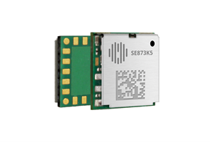 A small electronic module with a metallic cover labeled "SE873K5" and exposed gold connectors on the side of the green circuit board.