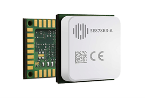 A close-up of a small electronic chip module with visible circuit board elements and a white cover labeled “SE878K3-A” and CE certification marks.