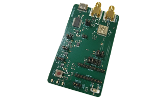 A green printed circuit board with electronic components, switches, connectors, a USB port, and two gold-colored coaxial connectors.