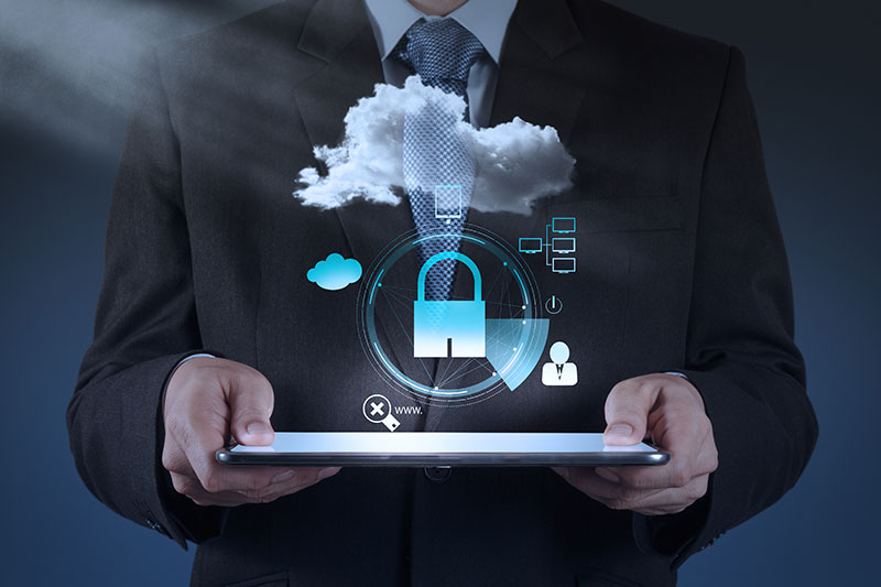 A person in a suit holds a tablet displaying a digital padlock and cloud icons, symbolizing cloud security and data protection.