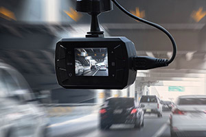 A close-up of a dashboard camera mounted inside a car.