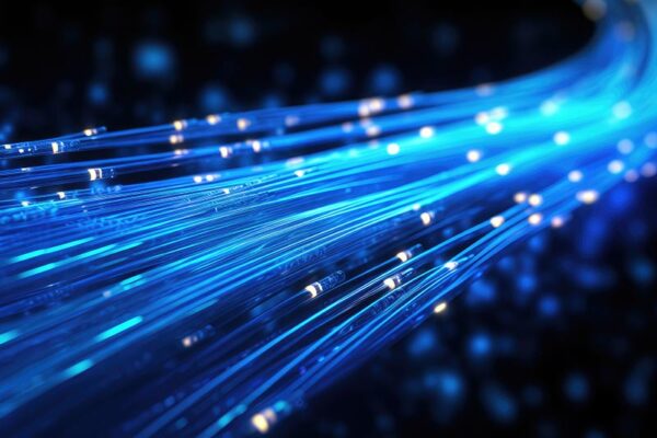 Close-up view of glowing blue fiber optic cables on a dark background, illustrating data transmission.