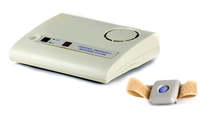 A personal emergency response system with a beige base unit and a wearable gray alert button on a strap.