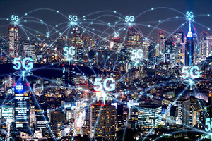 A city skyline at night with 5G symbols and network connections digitally illustrated above buildings, representing 5G wireless technology coverage.