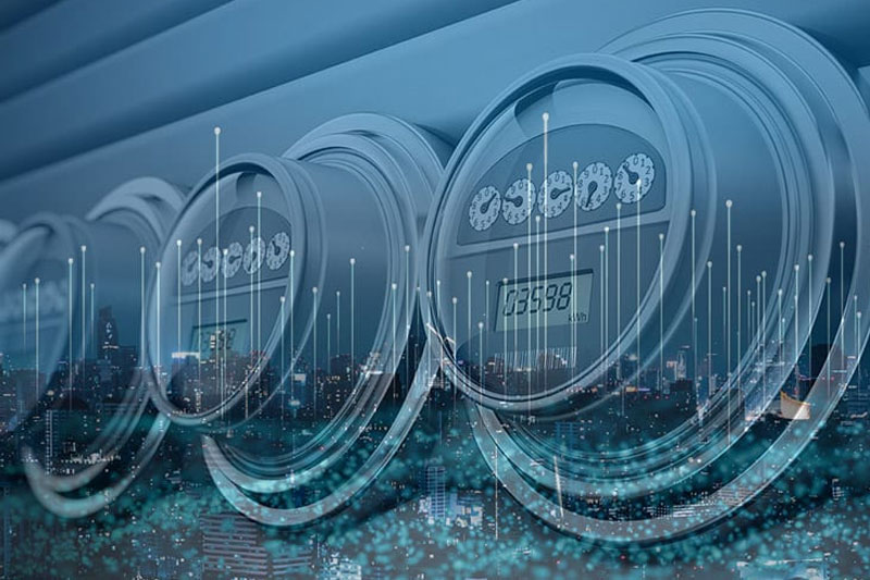 A row of digital electric meters is overlaid with a cityscape and abstract lines representing data and connectivity.