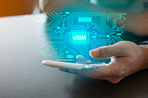 Person holding a smartphone with a digital hologram displaying an electronic SIM (eSIM) chip and circuit pattern above the device.